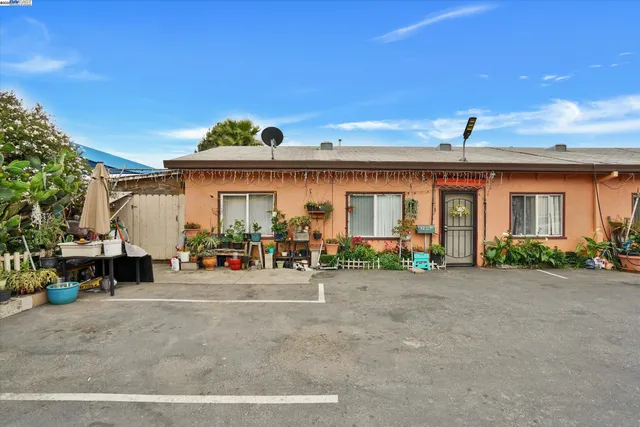 a view of a house with potted plants and a car parked
