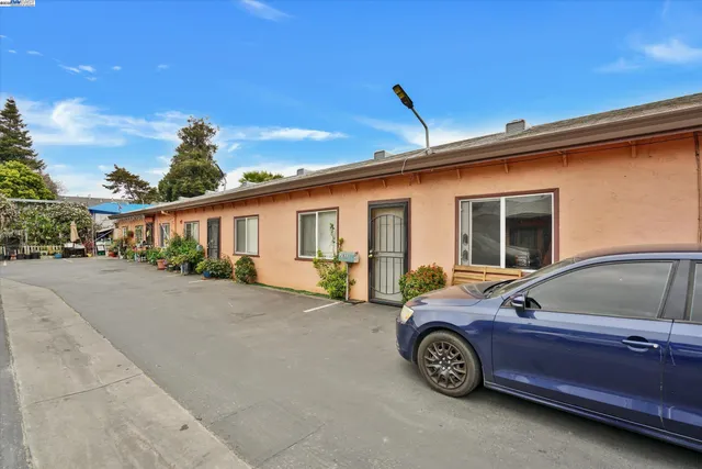 a front view of a house with a garden and parking