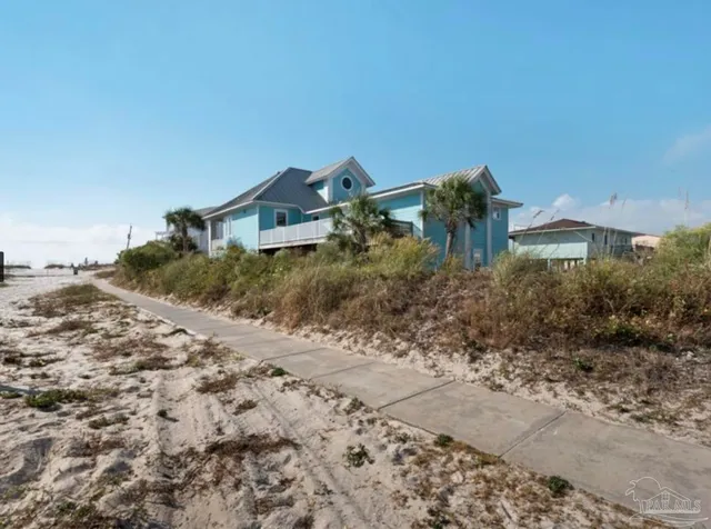 a view of a dry yard with wooden fence