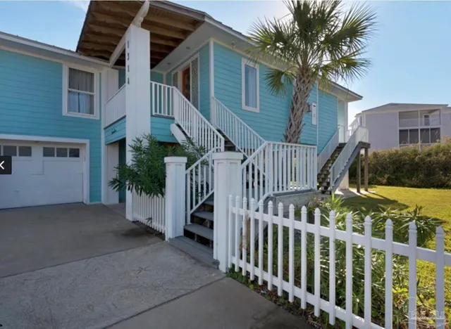 a view of a house with wooden fence