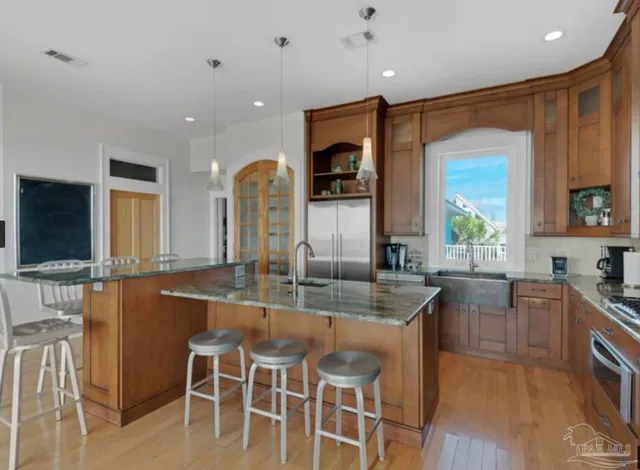 a kitchen with kitchen island granite countertop wooden cabinets and stainless steel appliances