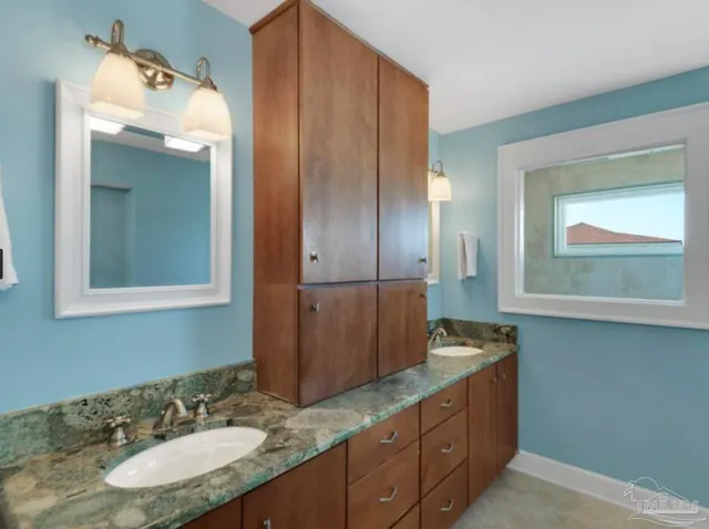 a bathroom with a granite countertop sink and a mirror