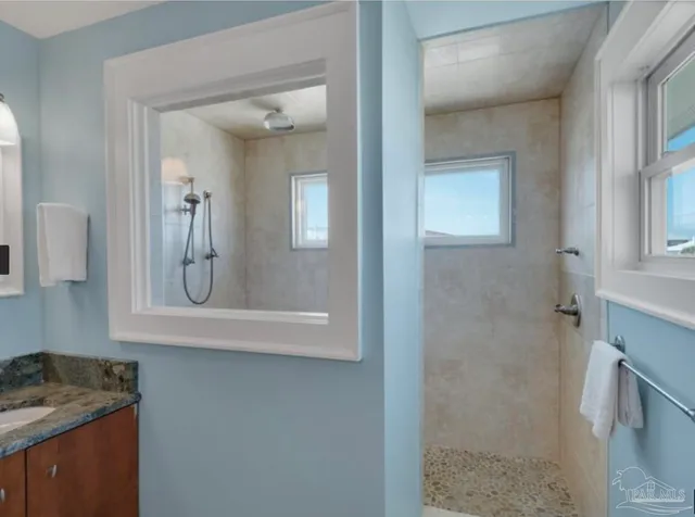 a bathroom with a granite countertop sink and a mirror