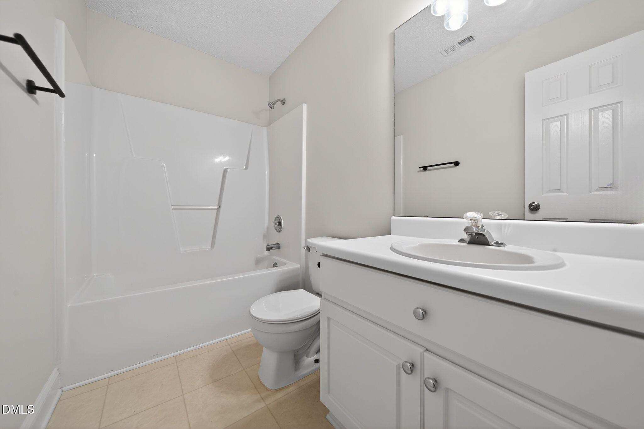 641 Commander Drive Wendell, NC 27591 - Photo 14 of 15 a bathroom with a sink a toilet and a large mirror