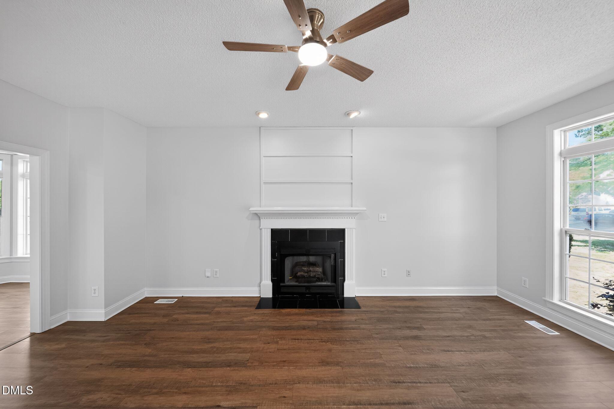 641 Commander Drive Wendell, NC 27591 - Photo 3 of 15 a view of an empty room with wooden floor fireplace and a window