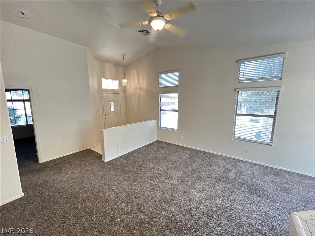1840 Montvale Las Vegas, NV 89134 - Photo 7 of 31 Step into a sun-filled living area featuring vaulted ceilings and fresh carpet.