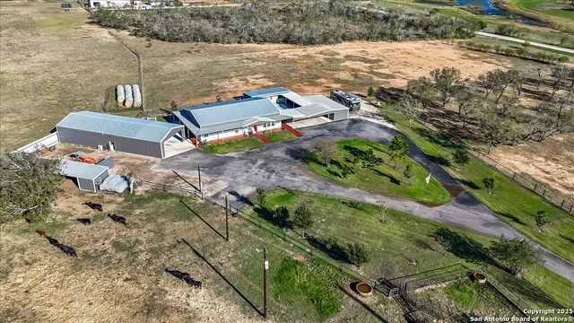 an aerial view of a house with a yard and lake view