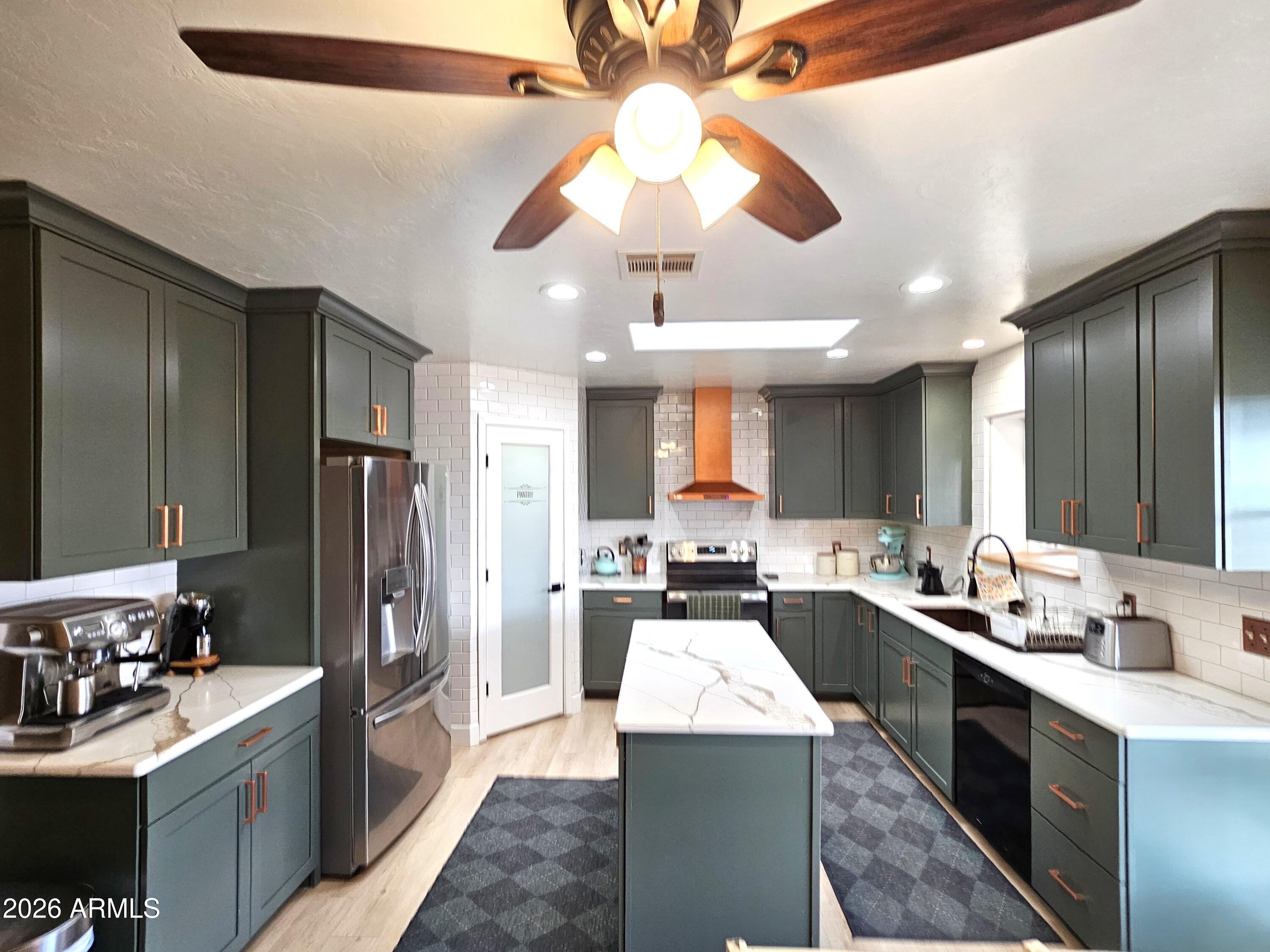 5705 South Wild Rose Road Hereford, AZ 85615 - Photo 11 of 39 a kitchen with a sink stainless steel appliances and cabinets