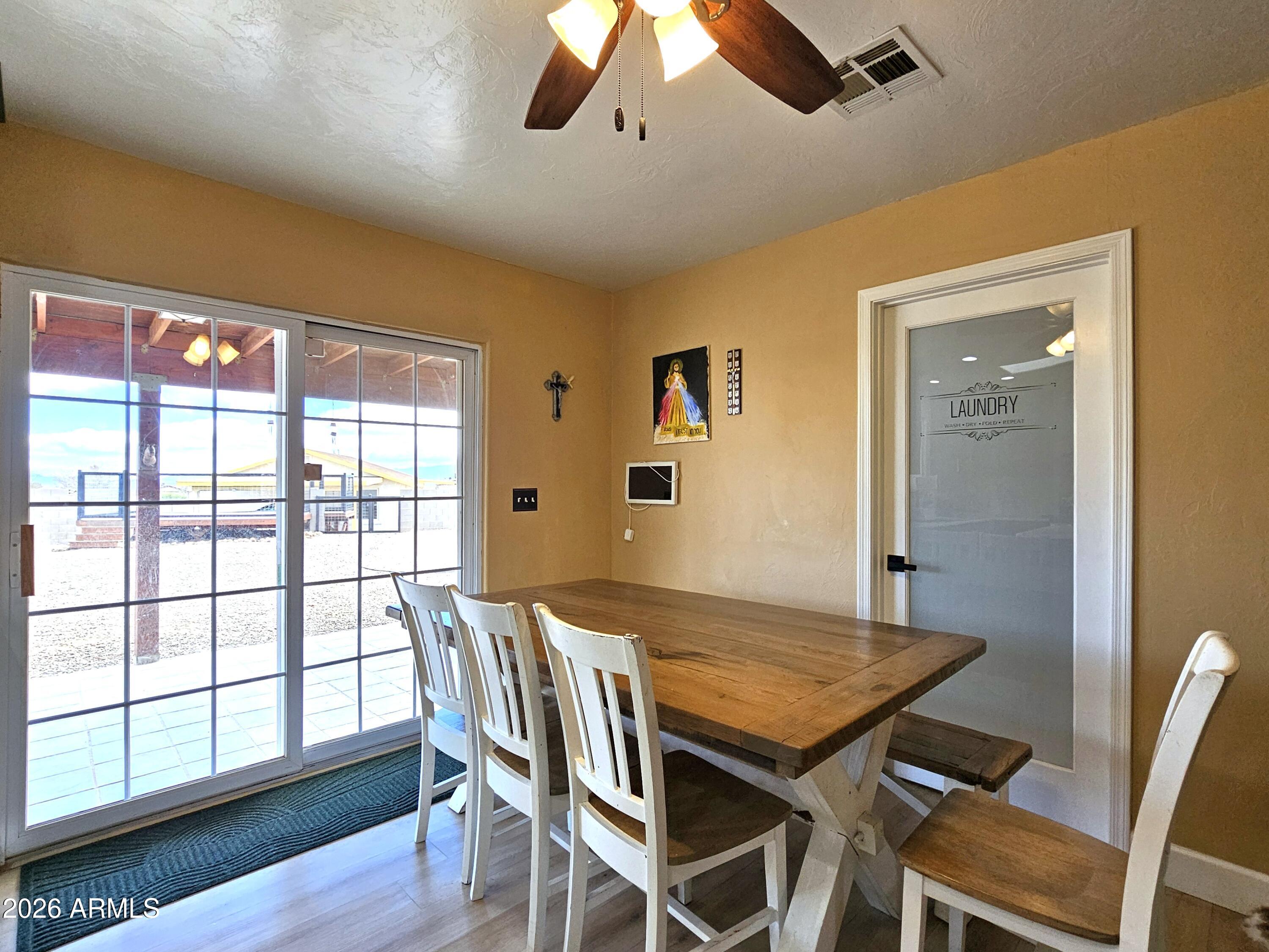5705 South Wild Rose Road Hereford, AZ 85615 - Photo 16 of 39 a view of a dining room with furniture window and wooden floor