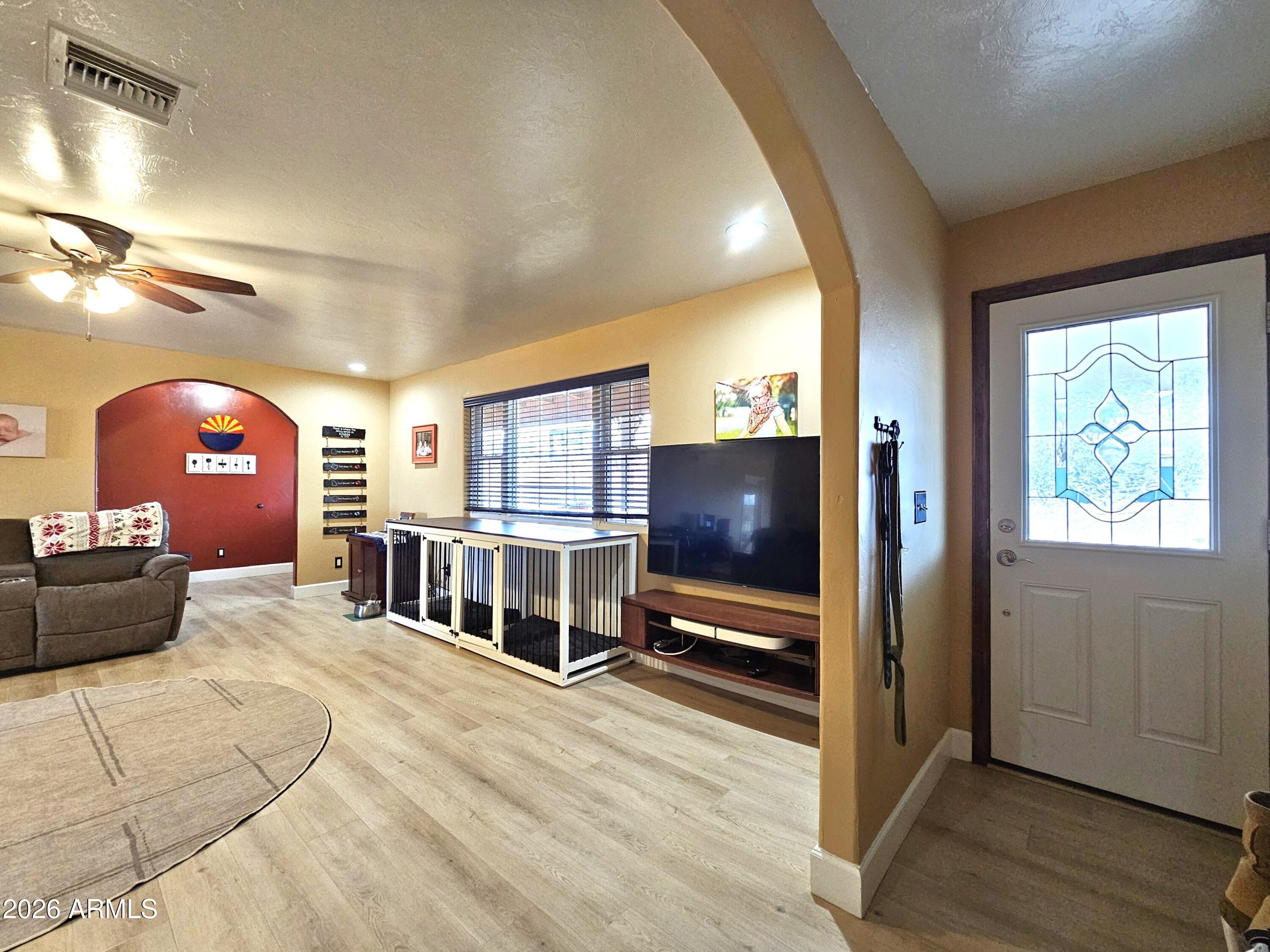 5705 South Wild Rose Road Hereford, AZ 85615 - Photo 7 of 39 a living room with furniture a flat screen tv and a large window