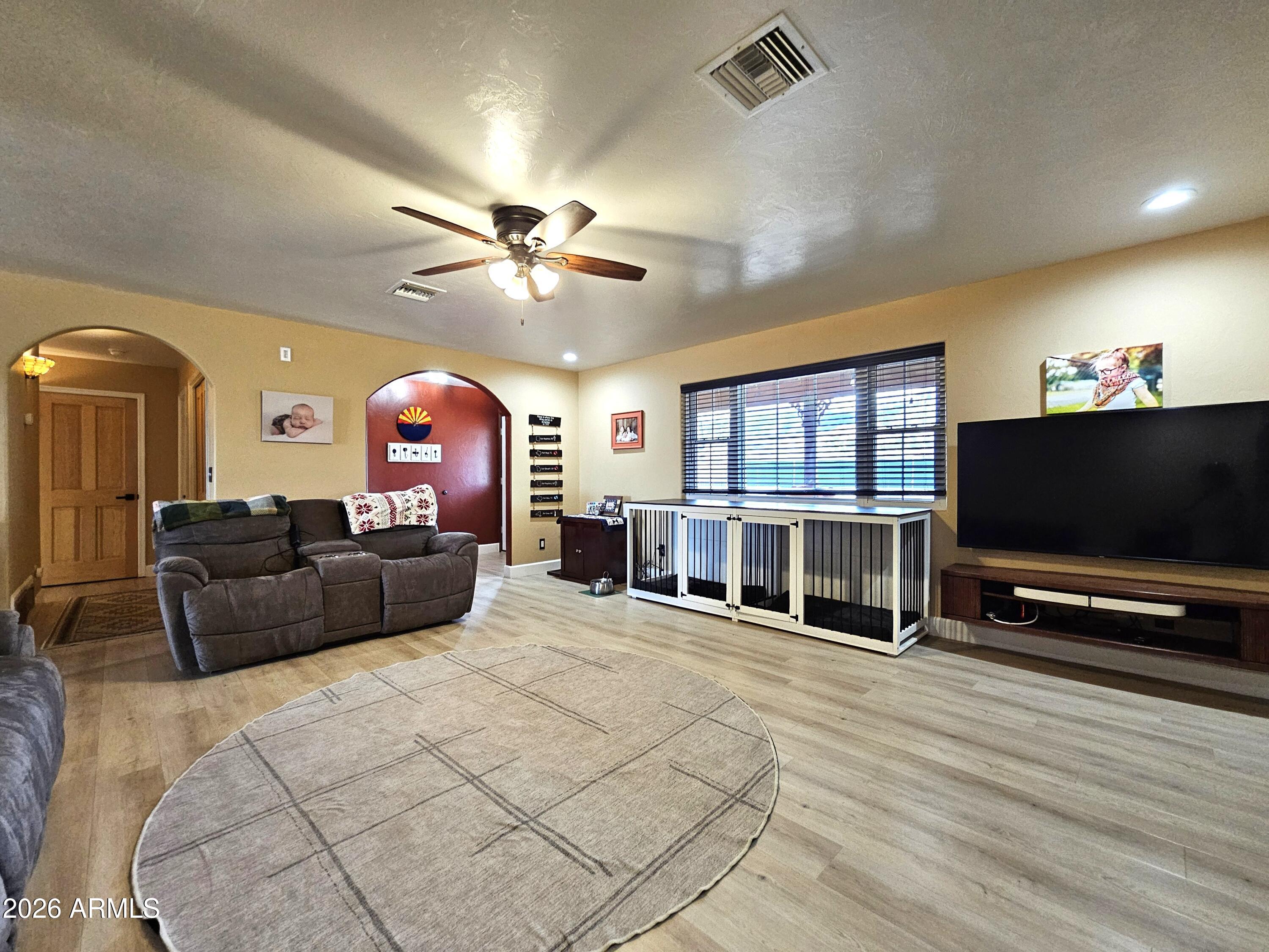 5705 South Wild Rose Road Hereford, AZ 85615 - Photo 9 of 39 a living room with furniture a flat screen tv and a floor to ceiling window