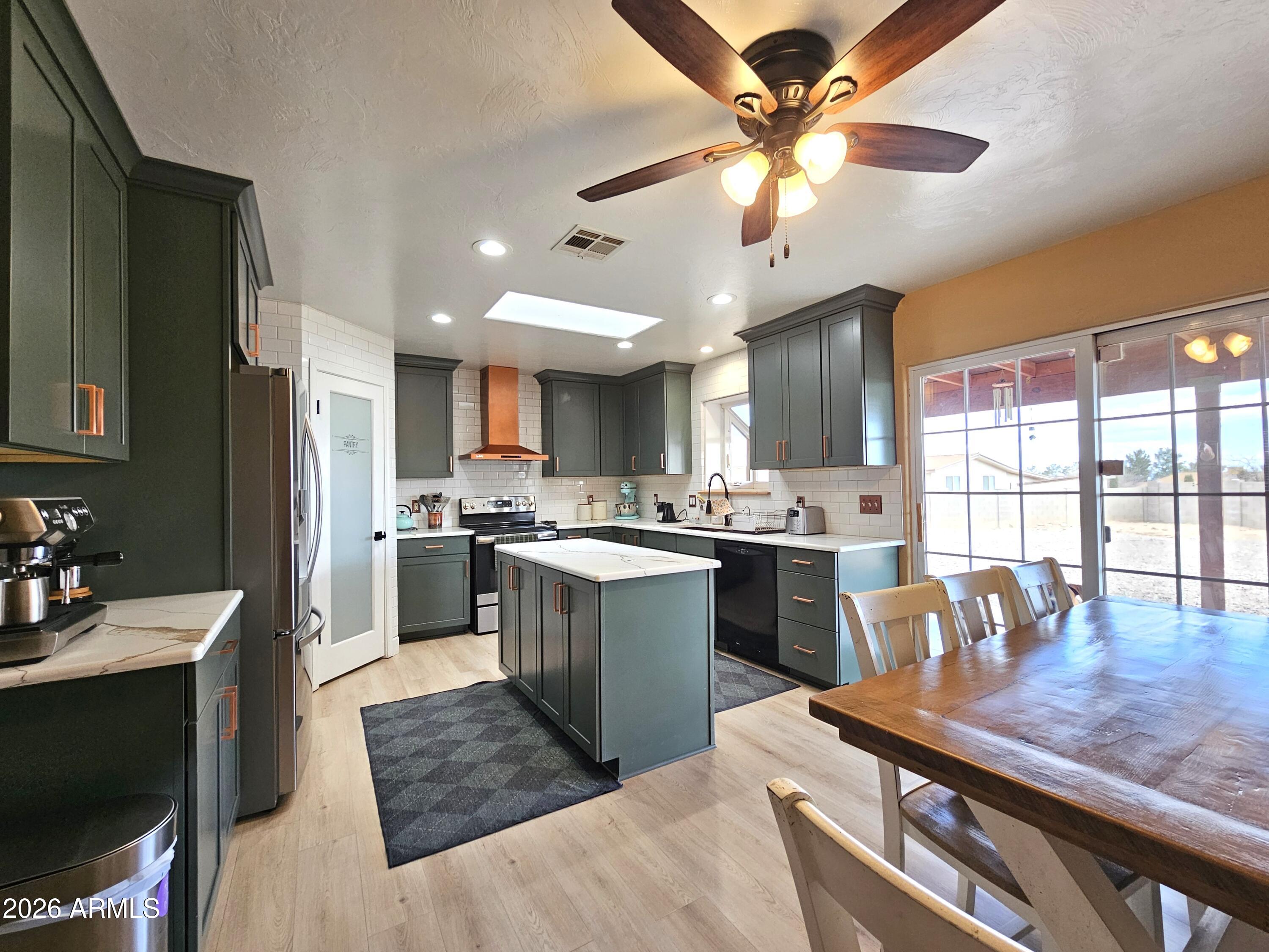 5705 South Wild Rose Road Hereford, AZ 85615 - Photo 10 of 39 a kitchen with a table chairs stove and refrigerator