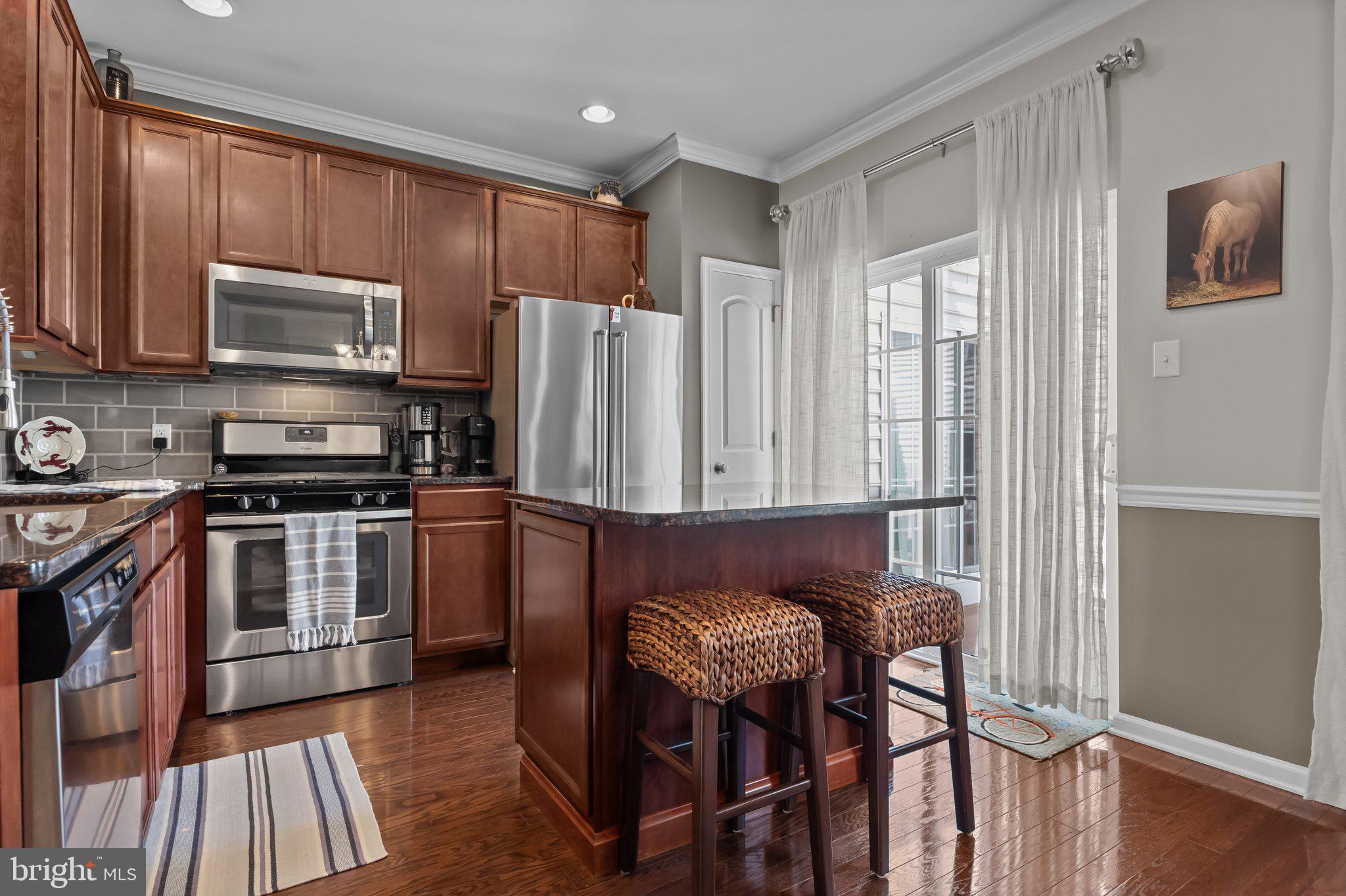 3799 Jacob Stout Road, Unit 9 Doylestown, PA 18902 - Photo 13 of 42 a kitchen with stainless steel appliances granite countertop a stove a refrigerator a sink a stove a dining table and chairs with wooden floor