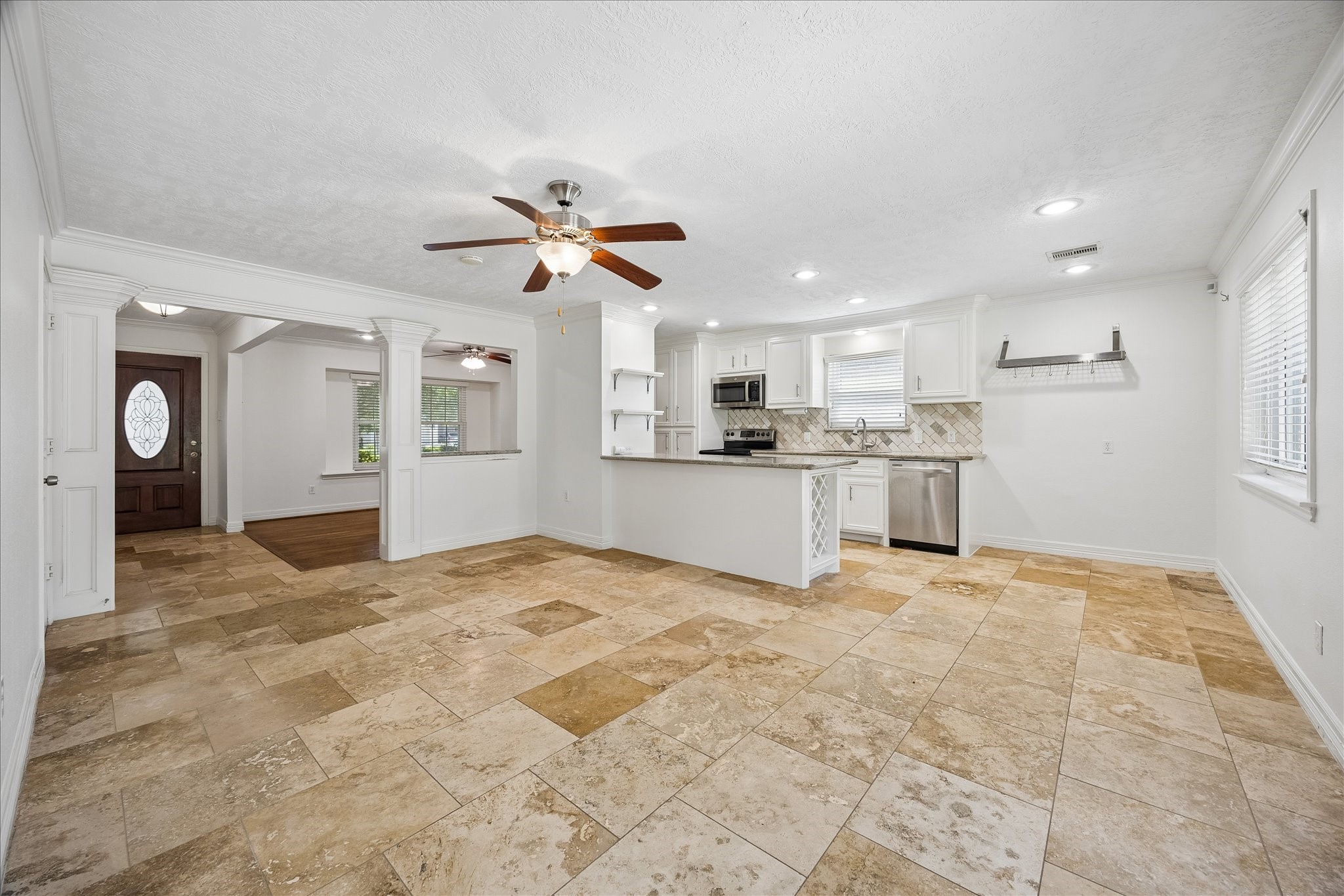 5019 Kinglet Street Houston, TX 77035 - Photo 23 of 24 Open floor plan is perfect for entertaining family & friends, with hardwood & travertine flooring, crown molding & kitchen open to the living areas.