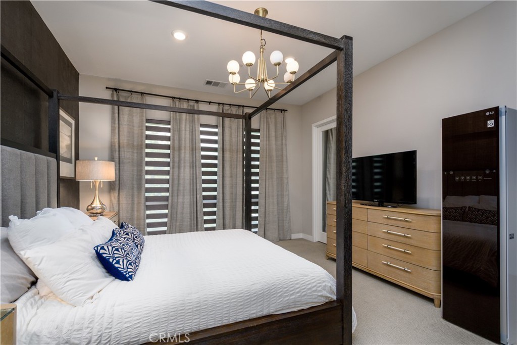 413 Transport Tustin, CA 92782 - Photo 17 of 47 a bedroom with a bed a flat screen tv and a chandelier