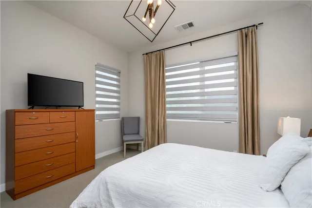 a bedroom with a bed and a chandelier