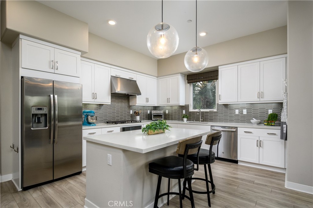 413 Transport Tustin, CA 92782 - Photo 7 of 49 a kitchen with a center island a counter space stainless steel appliances and cabinets