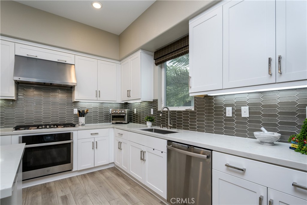 413 Transport Tustin, CA 92782 - Photo 8 of 49 a kitchen with white cabinets stainless steel appliances and sink