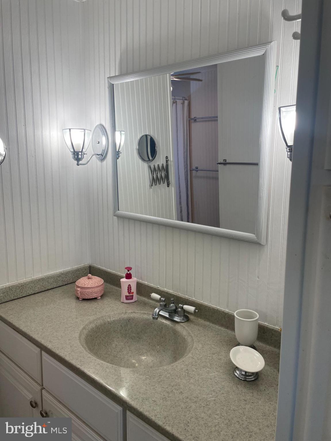 131-25 Priest Boulevard Rio Grande, NJ 08242 - Photo 24 of 35 a bathroom with a granite countertop sink and a mirror