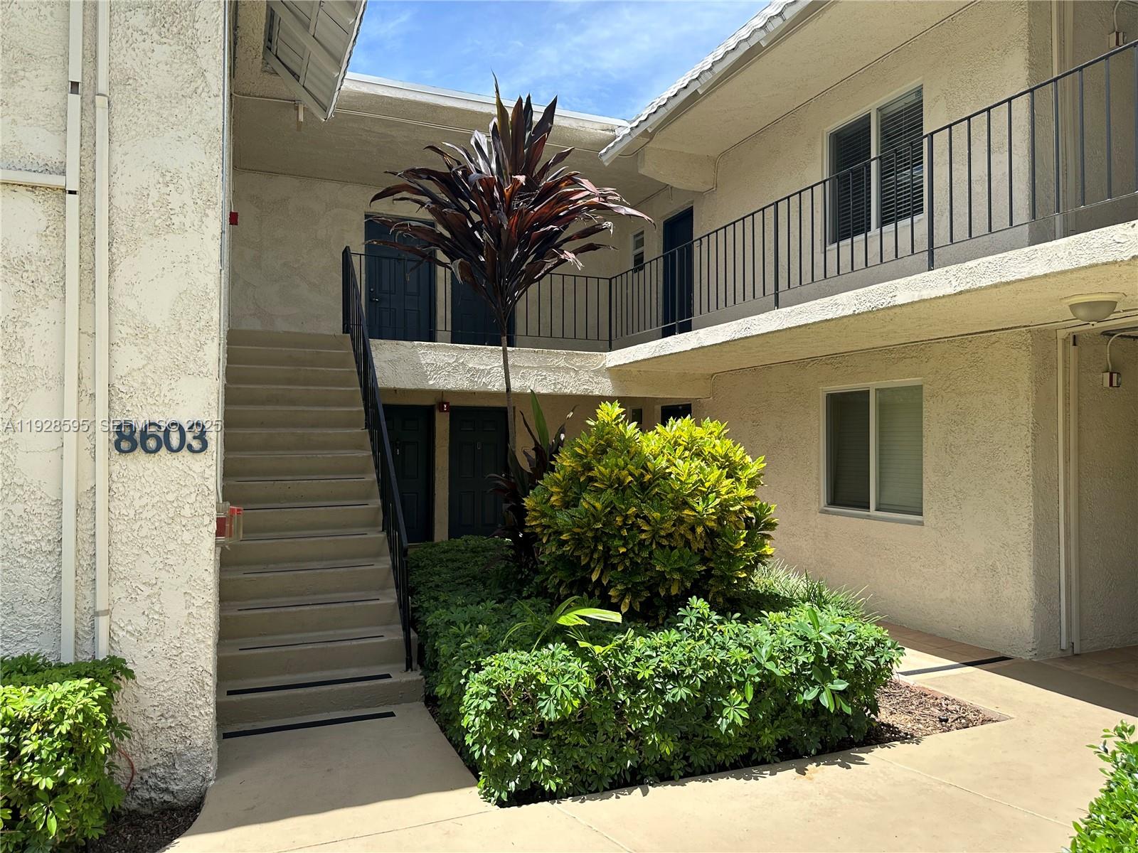 8603 Southwest 68th Court, Unit 26 Pinecrest, FL 33156 - Photo 1 of 13 a view of a house with a flower garden