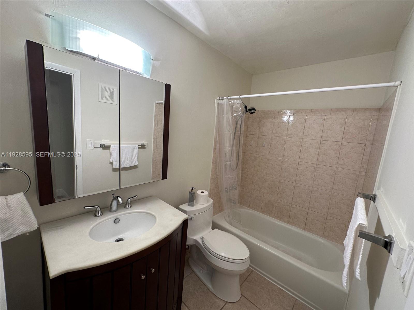 8603 Southwest 68th Court, Unit 26 Pinecrest, FL 33156 - Photo 7 of 13 a bathroom with a sink a toilet and shower