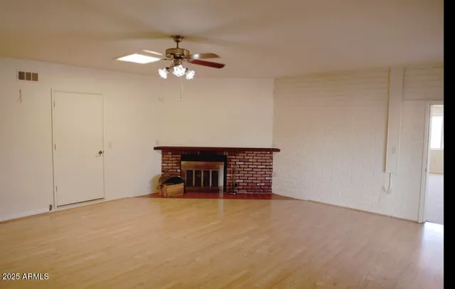a view of a livingroom with wooden floor and a ceiling fan