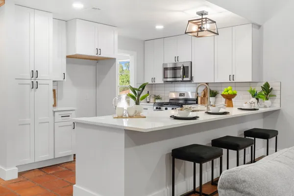 a kitchen with stainless steel appliances a sink a refrigerator and microwave