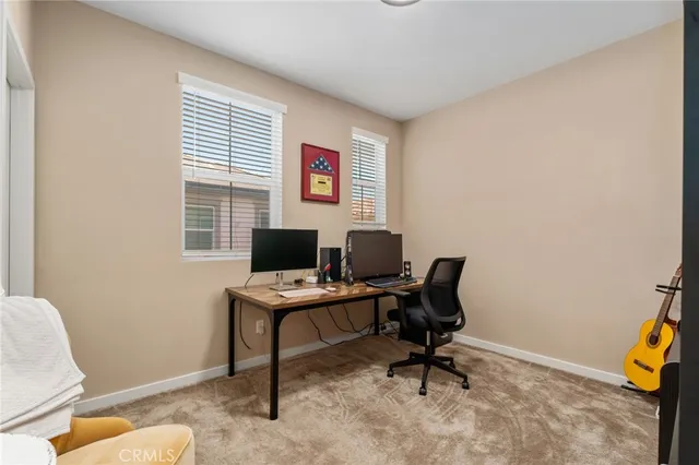 a view of a workspace with furniture and a window