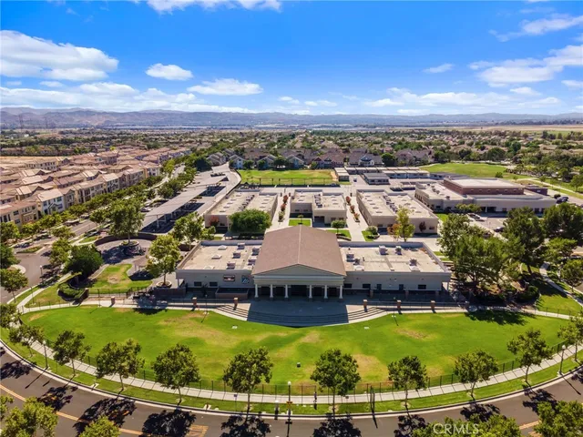 an aerial view of residential houses with outdoor space and trees