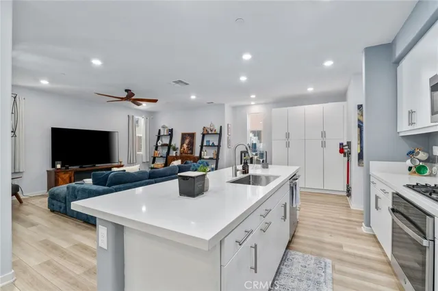 a large kitchen with stainless steel appliances a stove a sink a microwave and a refrigerator