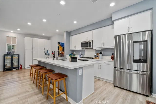 a kitchen with white cabinets and stainless steel appliances