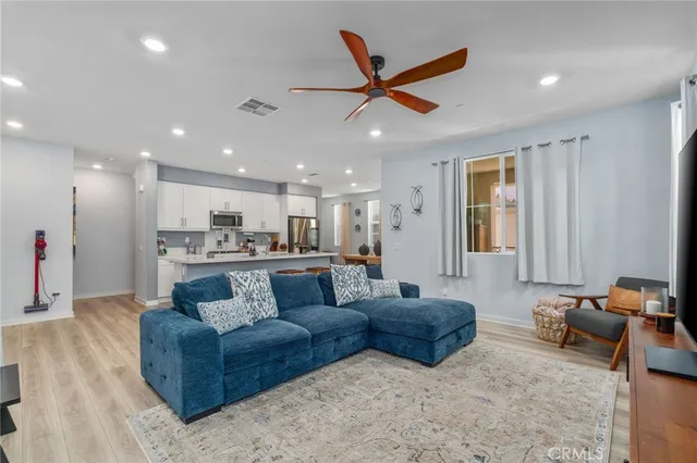 a living room with furniture kitchen view and a window