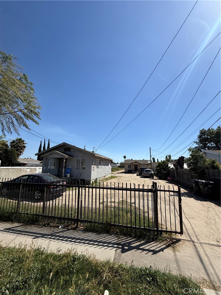 a view of a brick house with a small yard and wooden fence