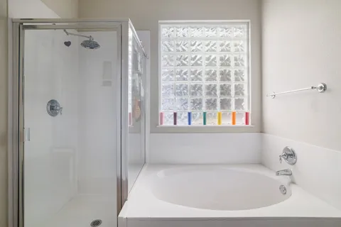 a white bath tub sitting next to a shower