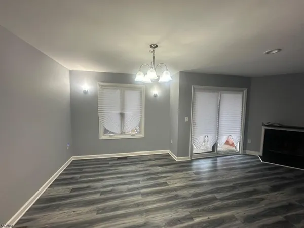 a view of wooden floor chandelier and entryway in a room