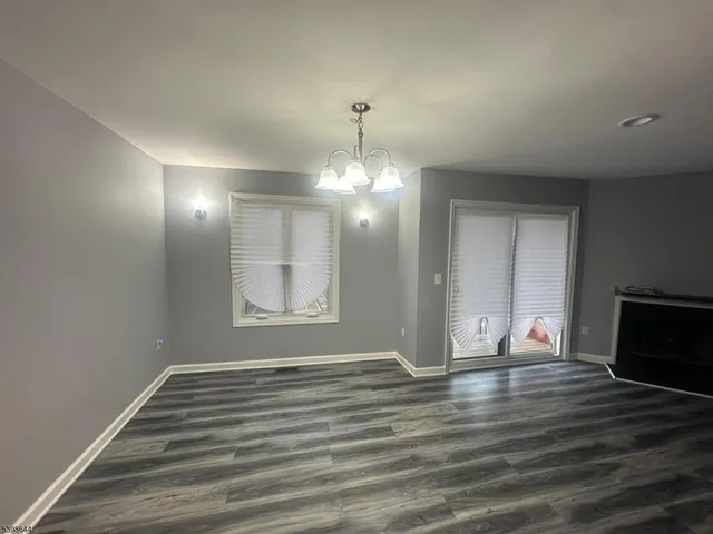 a view of wooden floor chandelier and entryway in a room
