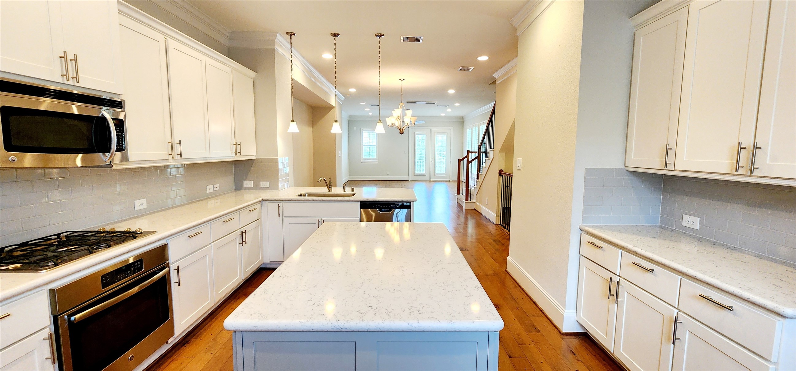 11 West Rafters Row The Woodlands, TX 77380 - Photo 14 of 31 a kitchen with granite countertop a stove top oven a sink dishwasher and white cabinets with wooden floor