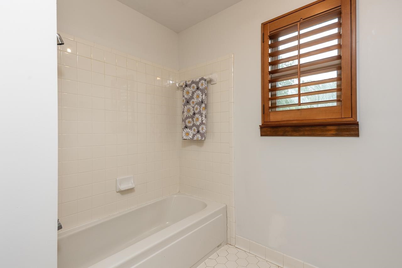 900 Center Point Drive Mason, TN 38049 - Photo 29 of 36 a bathroom with a bathtub a shower and a window