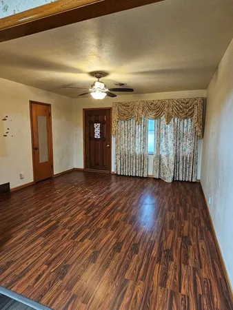 wooden floor in an empty room with a window