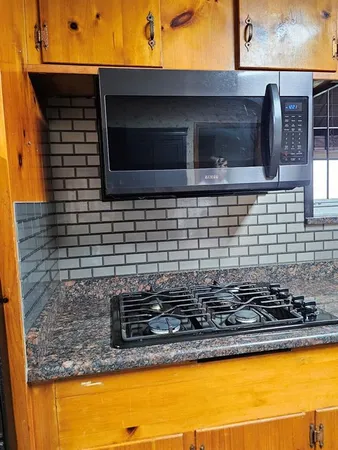 a bathroom with a granite countertop sink and a microwave