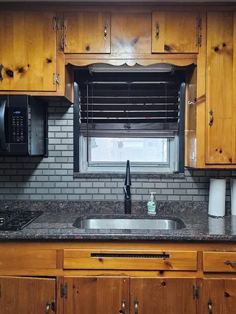 a kitchen with granite countertop a sink and cabinets