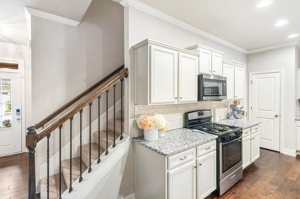 309 Braemore Mill Drive Lawrenceville, GA 30044 - Photo 7 of 9 a kitchen with granite countertop stainless steel appliances a stove sink and microwave