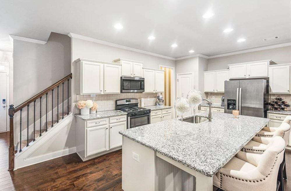 309 Braemore Mill Drive Lawrenceville, GA 30044 - Photo 8 of 9 a kitchen with stainless steel appliances granite countertop a sink refrigerator and microwave