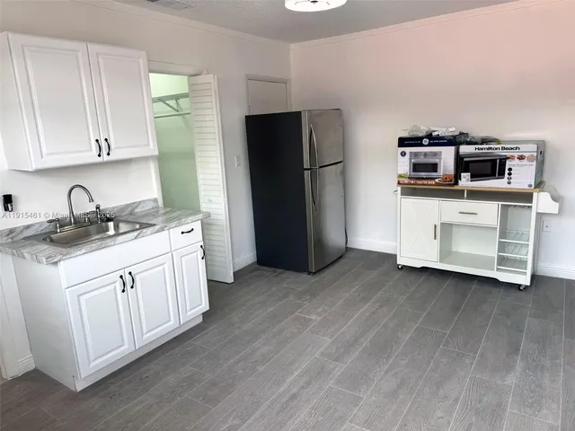 a kitchen with white cabinets and refrigerator