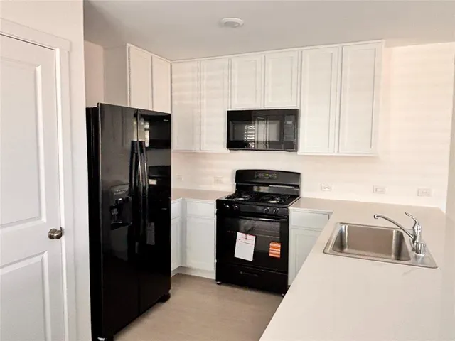 a kitchen with stainless steel appliances a refrigerator stove and microwave