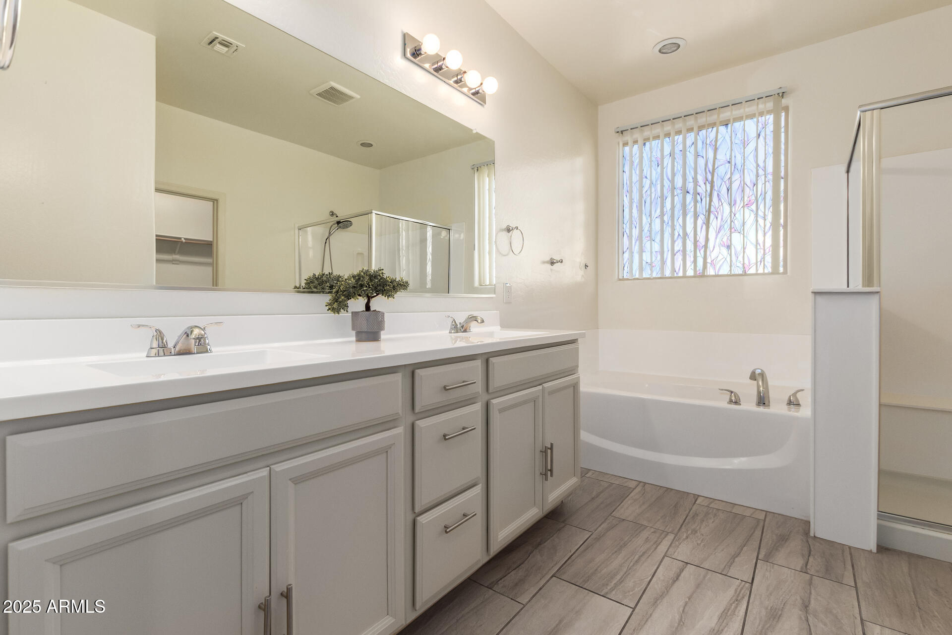 4515 West Pearce Road Laveen, AZ 85339 - Photo 14 of 35 a spacious bathroom with a double vanity sink a mirror and a bathtub
