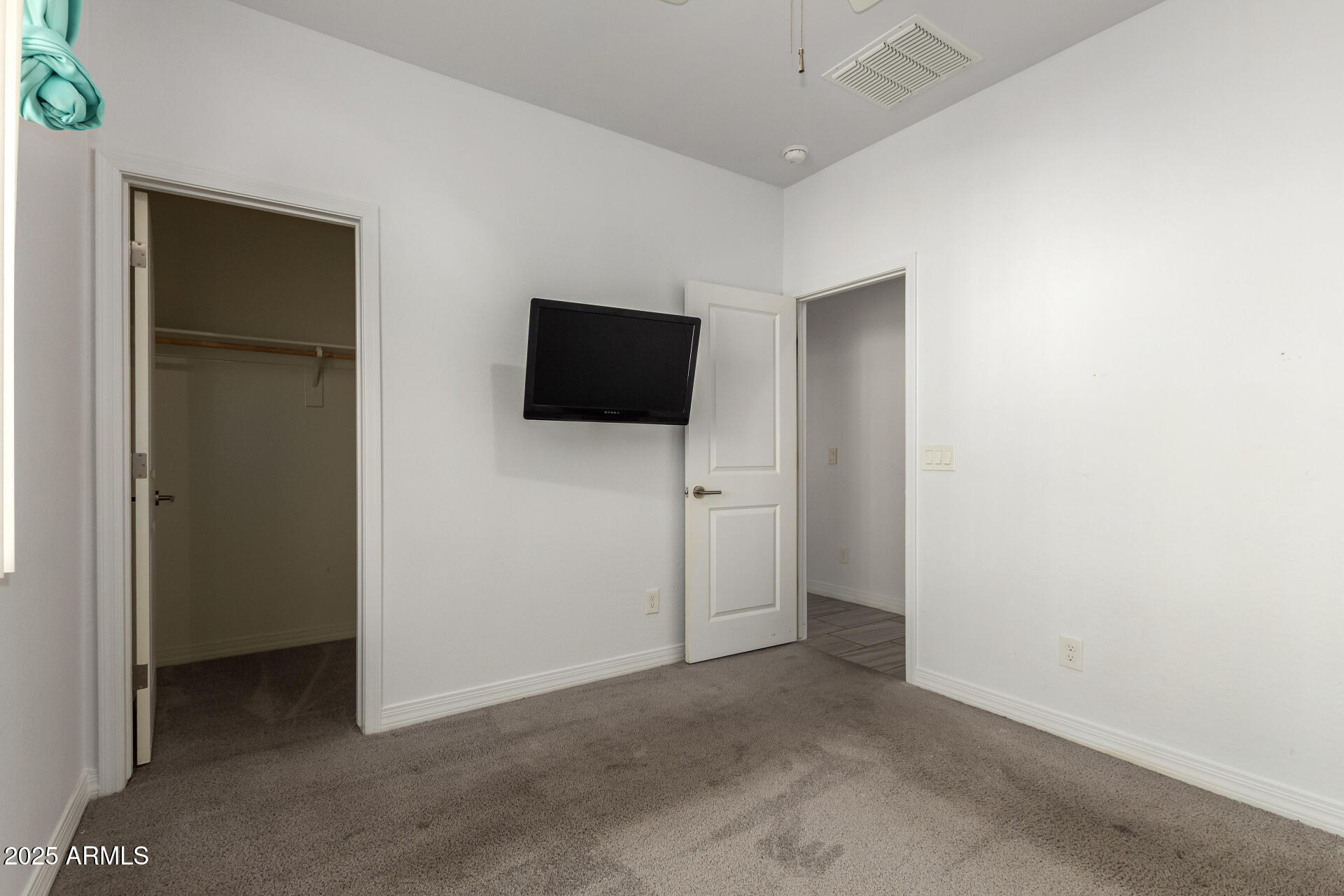 4515 West Pearce Road Laveen, AZ 85339 - Photo 17 of 35 an empty room with closet and a flat screen tv