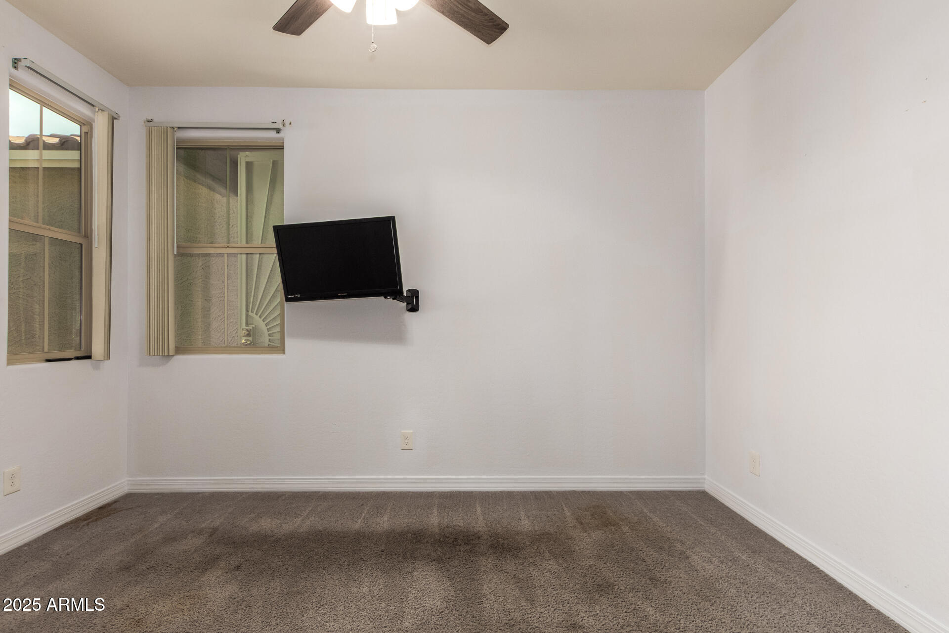 4515 West Pearce Road Laveen, AZ 85339 - Photo 21 of 35 an empty room with a flat tv screen and a lamp