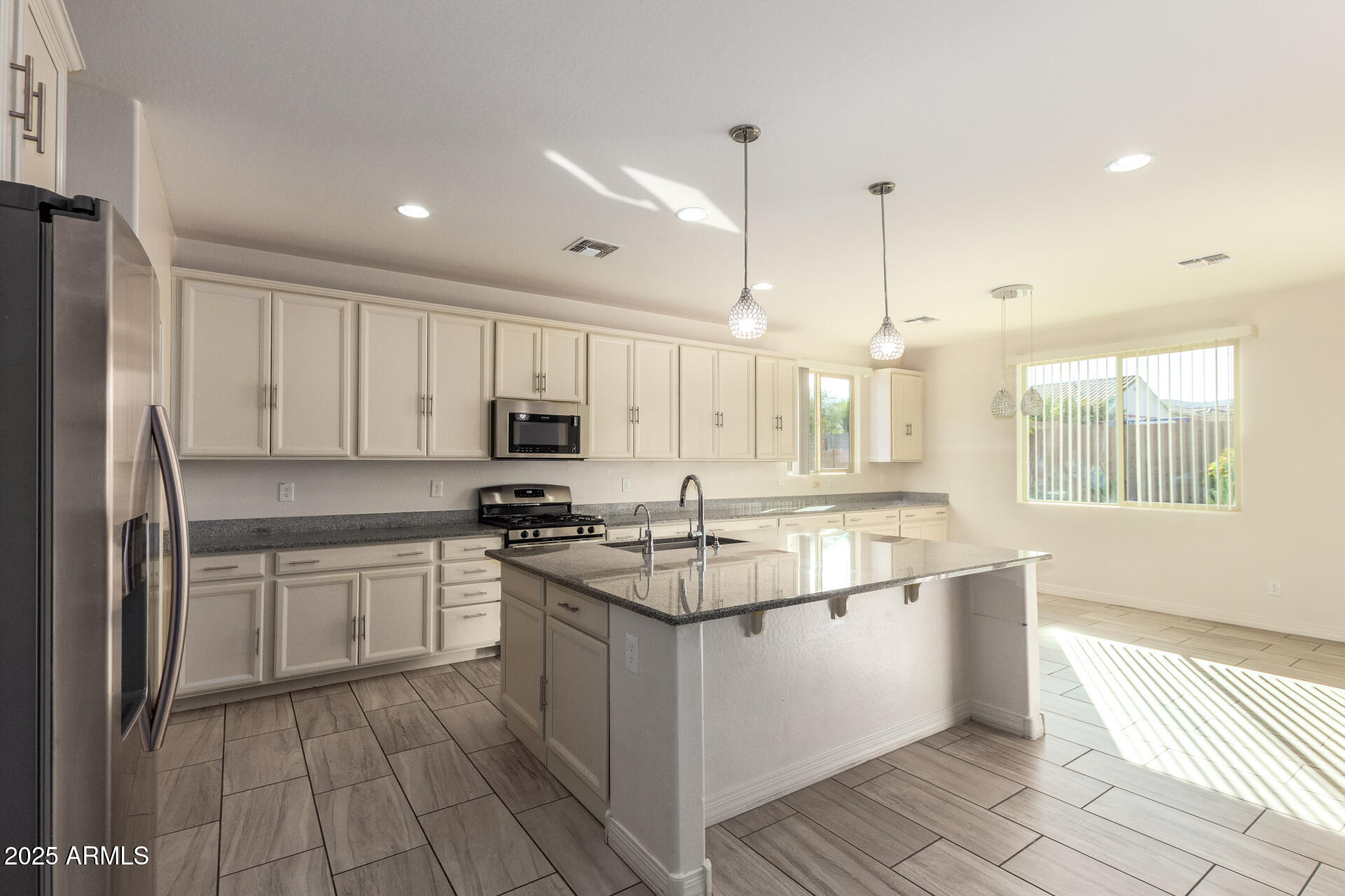 4515 West Pearce Road Laveen, AZ 85339 - Photo 6 of 35 a kitchen with stainless steel appliances granite countertop a stove a sink and a refrigerator