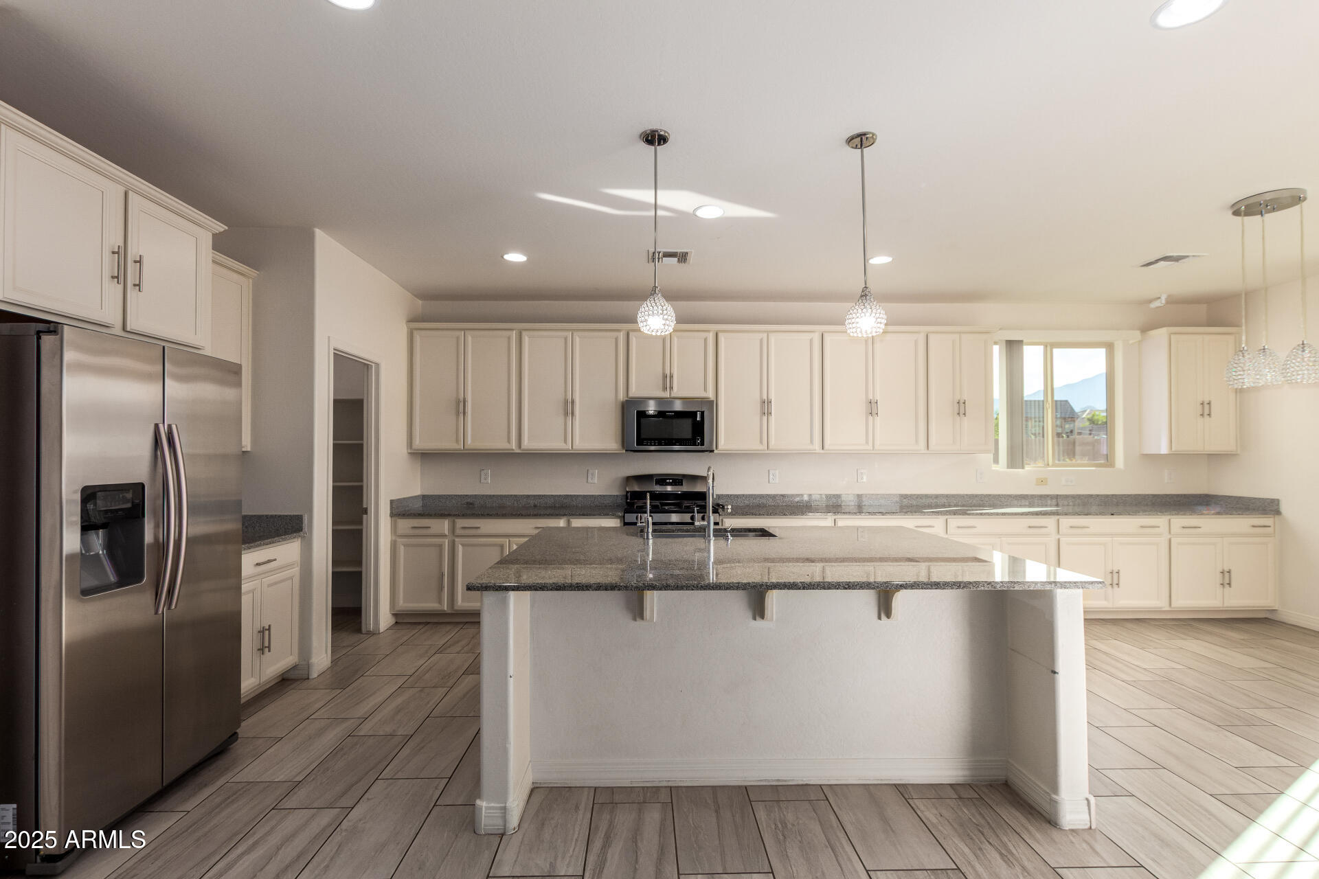 4515 West Pearce Road Laveen, AZ 85339 - Photo 7 of 35 a large kitchen with stainless steel appliances kitchen island a large counter top and wooden floors